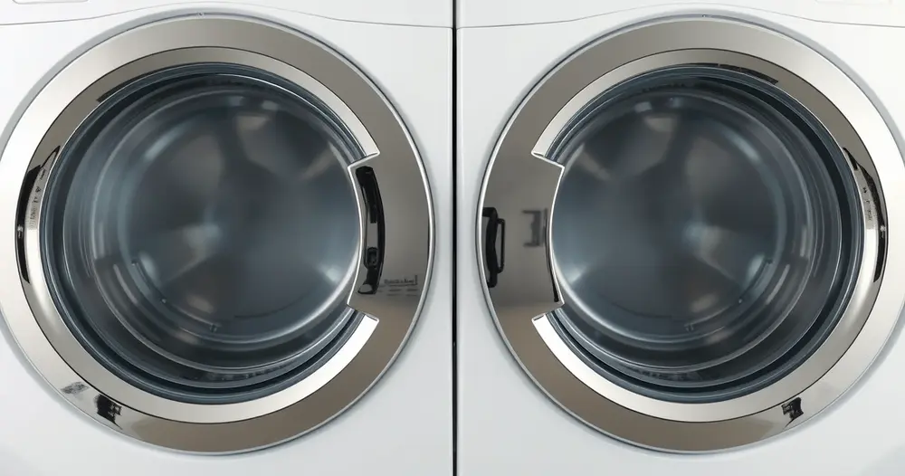 Portas redondas de duas máquinas de lavar roupa posicionadas lado a lado